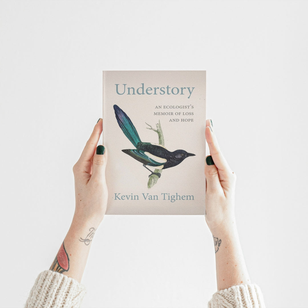 An image of someone's hands holding up a copy of Kevin Van Tighem's latest book, Understory, in front of a plain white background.
